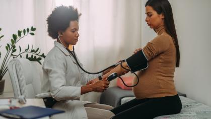 Nursing student takes blood pressure of a pregnant woman